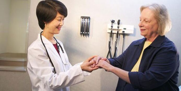 il medico esamina le dita per il dolore